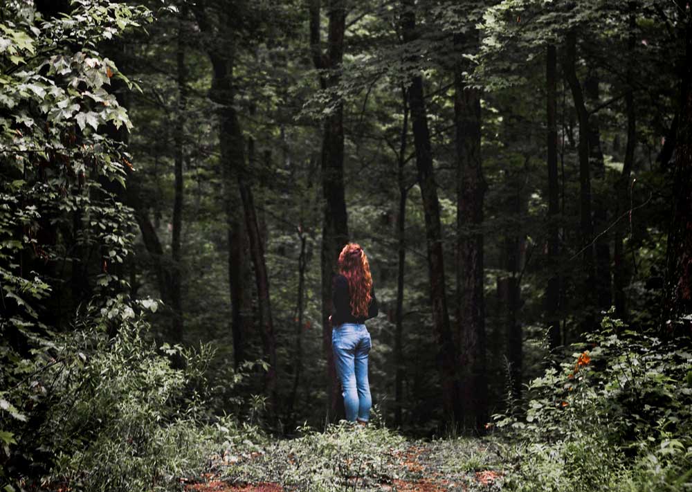 Woman in the woods thinking about her support program with Amy.